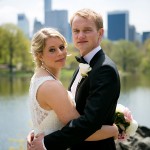 Bride and groom hug with NYC skyline in background