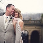 Bride stands behind groom with Bethesda Arcade in background