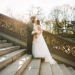 Bride and groom posing on steps of Bethesda Fountain Central Park