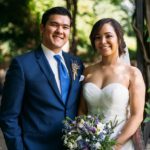 Bride and Groom posing under the Wisteria Pergola in Conservatory Garden