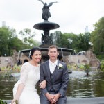 Bride and groom sitting on the edge of Bethesda Fountain