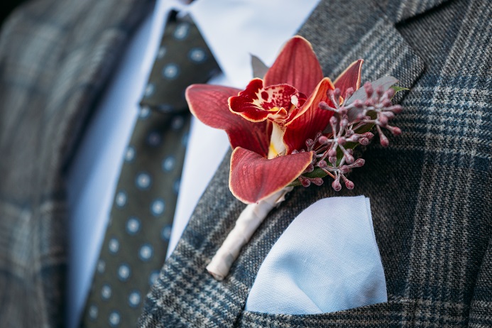 red orchid boutonniere with seeded eucalyptus