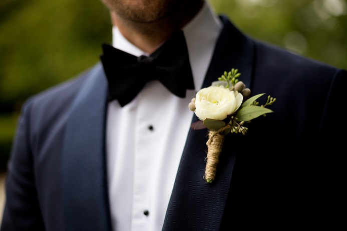 White ranunculus boutonniere with silver brunia