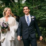 Bride holding bouquet walks with groom in Central Park