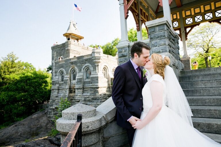 Newlyweds kissing with Belvedere Castle tower in background