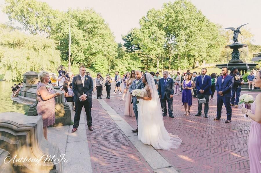 Bride walks down aisle with dad at Bethesda Fountain in Central Park