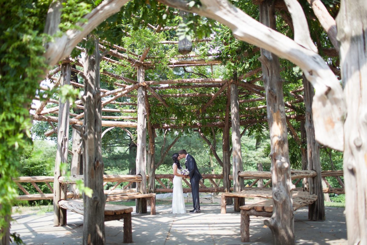 NYC Outdoor Wedding Venues & Locations: Bride and groom kiss inside empty Cop Cot gazebo