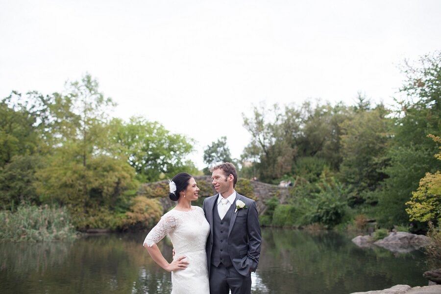 Newlyweds pose in front of Gapstow Bridge in the spring