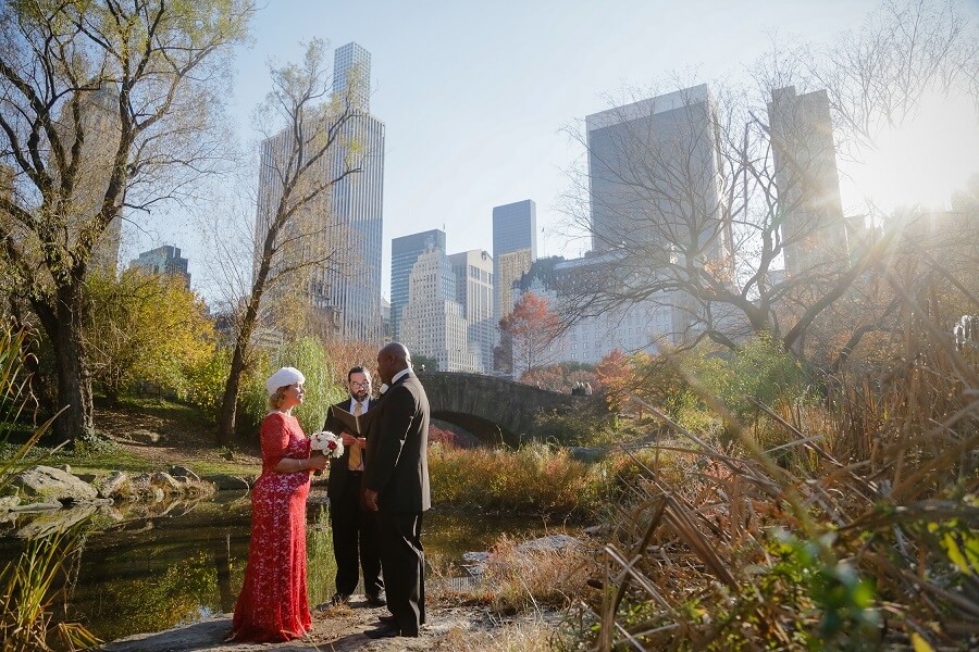 Fall elopement behind Gapstow Bridge with NYC skyline in background