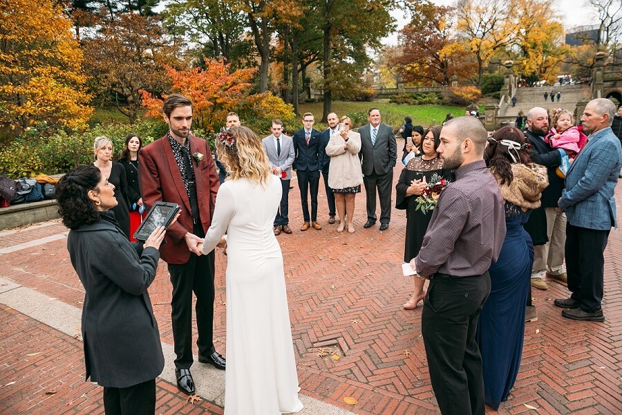 Couple exchanges wedding vows on fall day at Bethesda Fountain