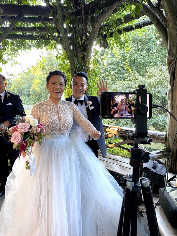 Bride and groom wave to virtual wedding guests