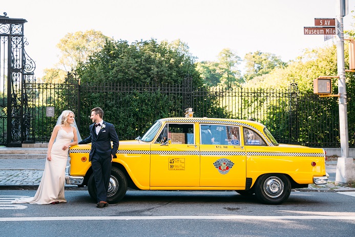 Bride and groom pose by vintage NYC checker cab