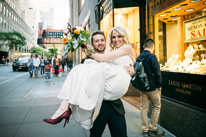 Groom carries bride through NYC streets
