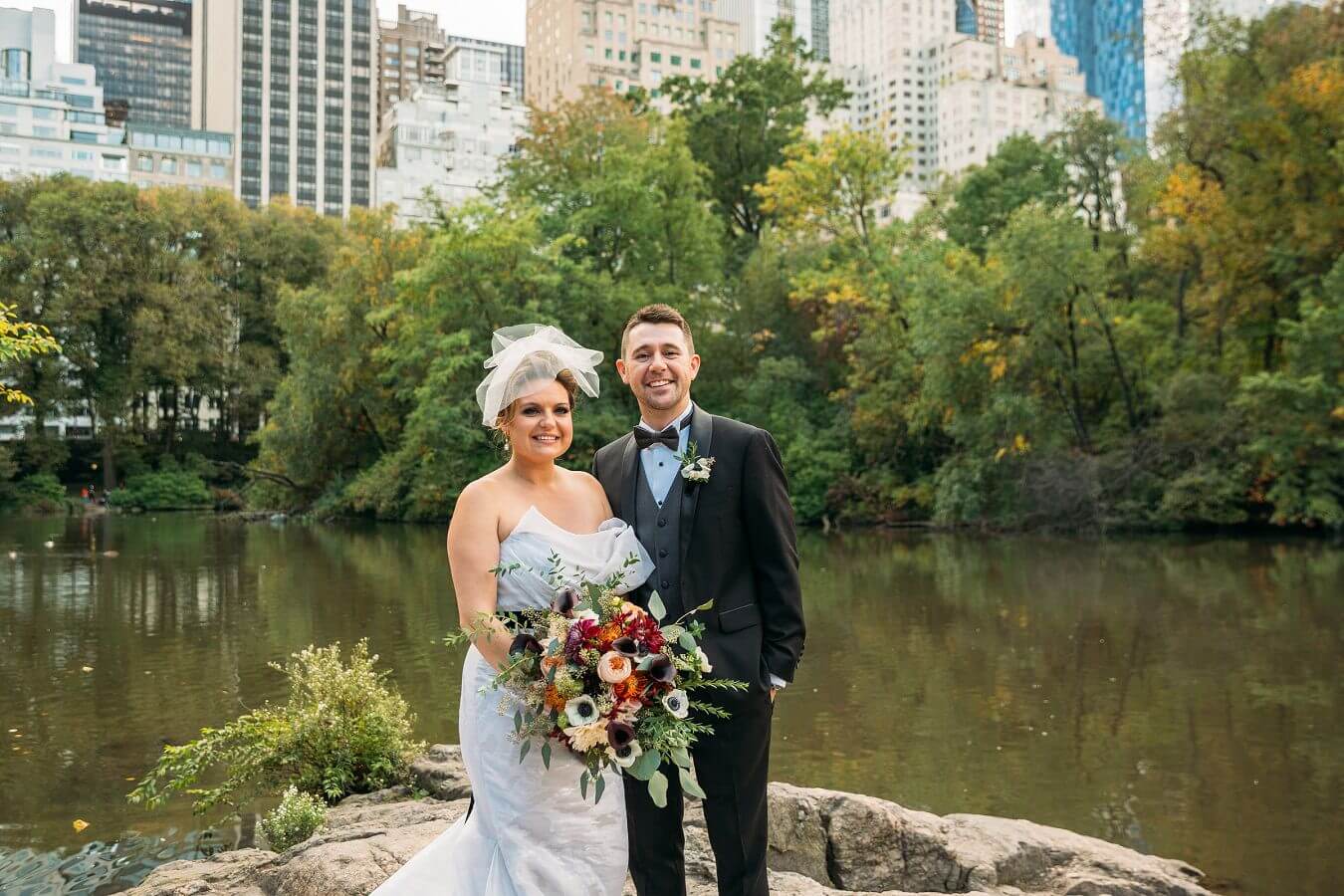 Wedding Couple poses by Gapstow Bridge with NYC Skyline