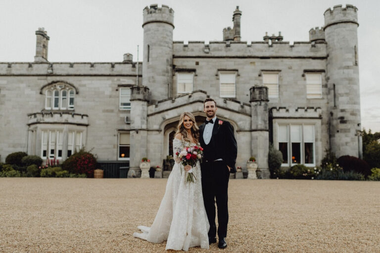 Newlyweds take portrait in front of Scottish castle